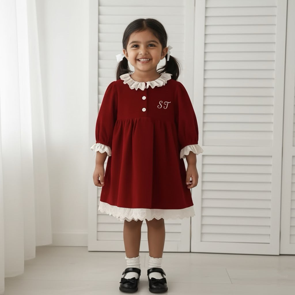 Girl stood wearing red dress with her initials on it